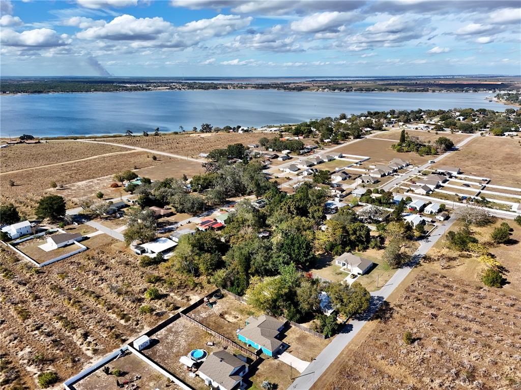 An aerial view shows a residential neighborhood situated along the shore of a large lake — FLORIDA STREET, FROSTPROOF, FL