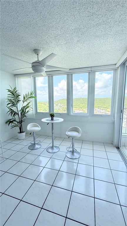 A sunroom with white tile floors, a ceiling fan, and a small table with chairs — 200 AVE MARINA VIEW DOS MARINAS II CONDOMINIUM UNIT 2307, FAJARDO, PR