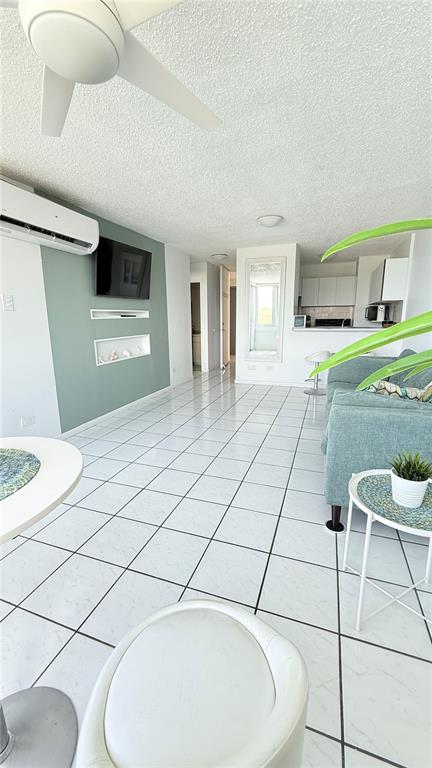 A living room with white tiled floors, a green accent wall, and a ceiling fan — 200 AVE MARINA VIEW DOS MARINAS II CONDOMINIUM UNIT 2307, FAJARDO, PR