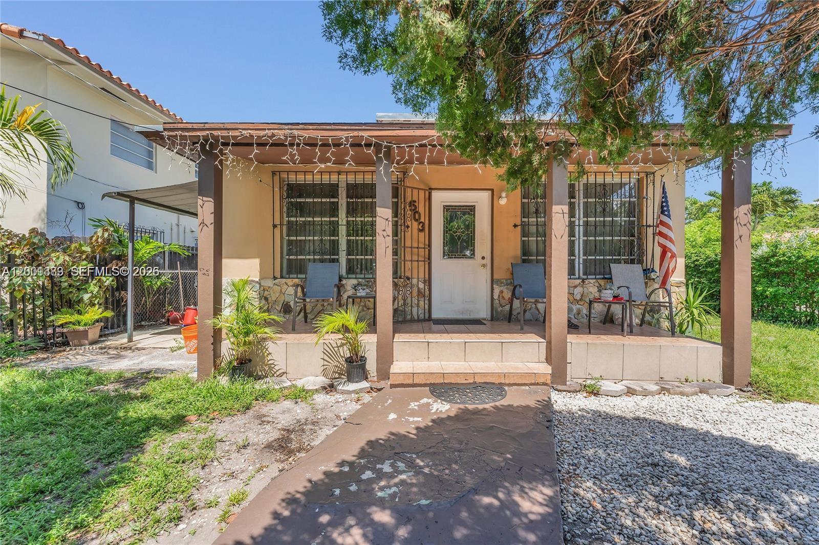 A single-story house features a covered front porch with stone accents and security bars — 503 NW 43rd Pl, Miami FL 33126, MIAMI, FL
