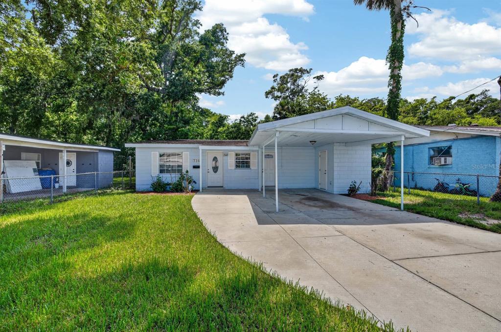 A light blue single-story house features a concrete driveway and an attached carport — 736 S CAROLINE STREET, DAYTONA BEACH, FL