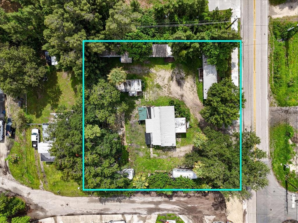 An aerial view shows a rectangular lot containing a house and several outbuildings among trees — 9890 ORANGE RIVER BOULEVARD, FORT MYERS, FL