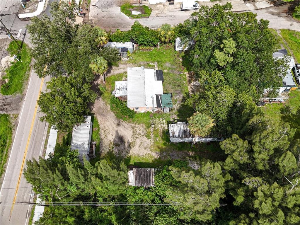 An aerial view shows a house with a metal roof surrounded by trees and outbuildings — 9890 ORANGE RIVER BOULEVARD, FORT MYERS, FL