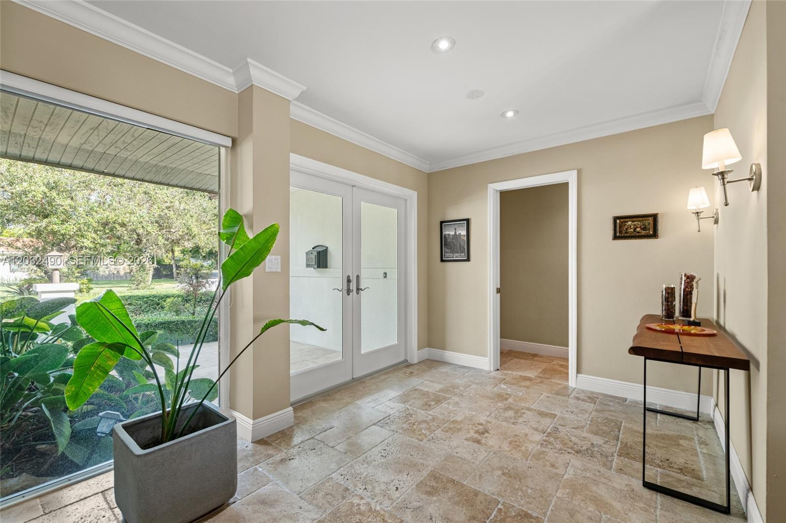 An entryway features travertine tile flooring, a potted plant, a console table, and double doors — 7360 SW 115th St, Pinecrest FL 33156, PINECREST, FL