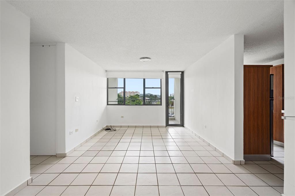 An empty room with white walls, tiled floors, a large window, and a glass door — 37 Atrium Park CALLE REGINA MEDINA UNIT C-604, GUAYNABO, PR