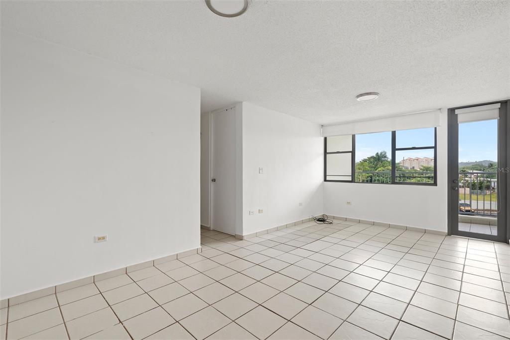 An empty room with white walls, light-colored tile flooring, and a glass door to a balcony — 37 Atrium Park CALLE REGINA MEDINA UNIT C-604, GUAYNABO, PR