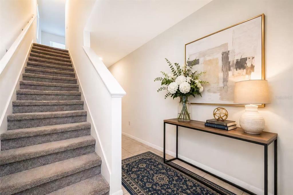 A two-story suburban house with a tan stucco exterior and a two-car garage — 30915 PENNY SURF LOOP, WESLEY CHAPEL, FL