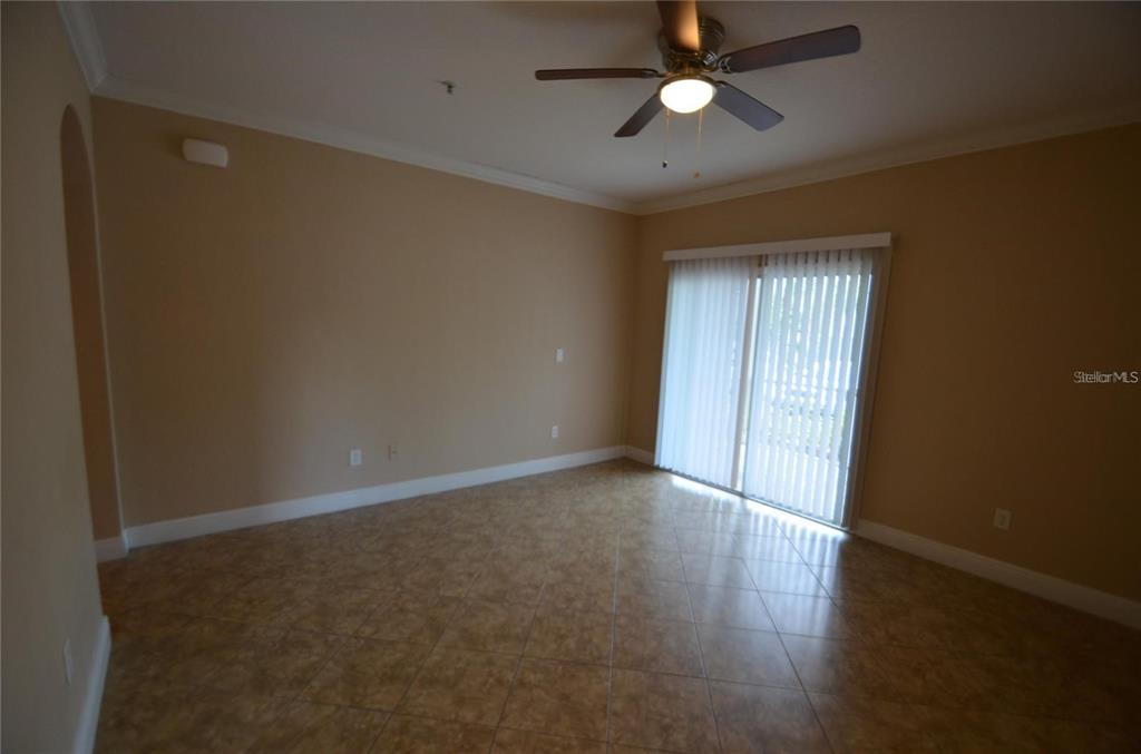 An empty room with tan walls, tile flooring, a ceiling fan, and sliding glass doors — 3725 S LAKE ORLANDO PKWY UNIT 1, ORLANDO, FL