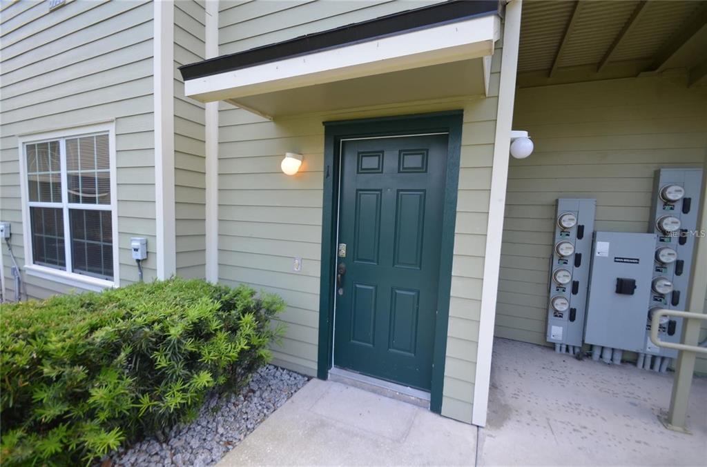 A green front door with a small porch overhang and adjacent utility meters — 3725 S LAKE ORLANDO PKWY UNIT 1, ORLANDO, FL
