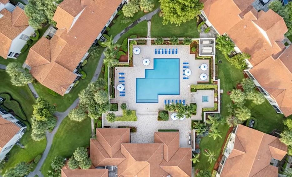 An aerial view shows a swimming pool and patio area surrounded by residential buildings — 800 The Pointe Drive, West Palm Beach FL 33409, WEST PALM BEACH, FL