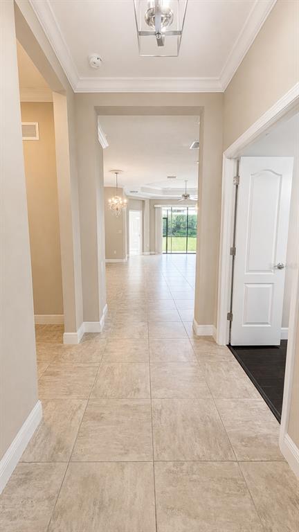 A tiled hallway leads toward an open living area with a view of the backyard — 4520 DEEP CREEK TERRACE, PARRISH, FL