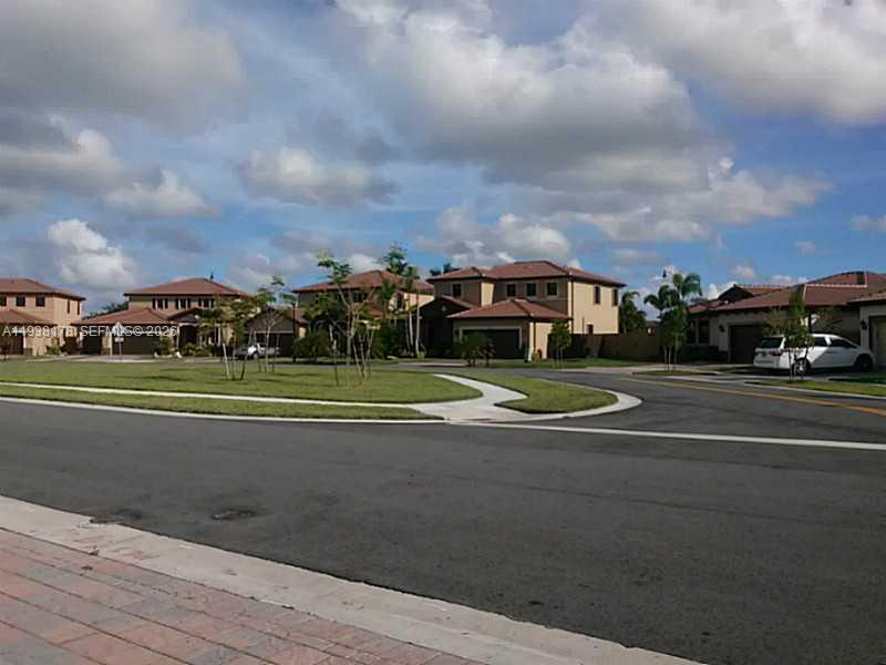 A suburban street scene features several two-story houses with tiled roofs and manicured lawns — 191 SE 35 TH AV., Homestead FL 33033, HOMESTEAD, FL