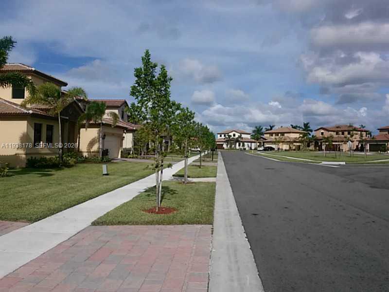 A residential street with houses, sidewalks, and young trees under a cloudy sky — 191 SE 35 TH AV., Homestead FL 33033, HOMESTEAD, FL