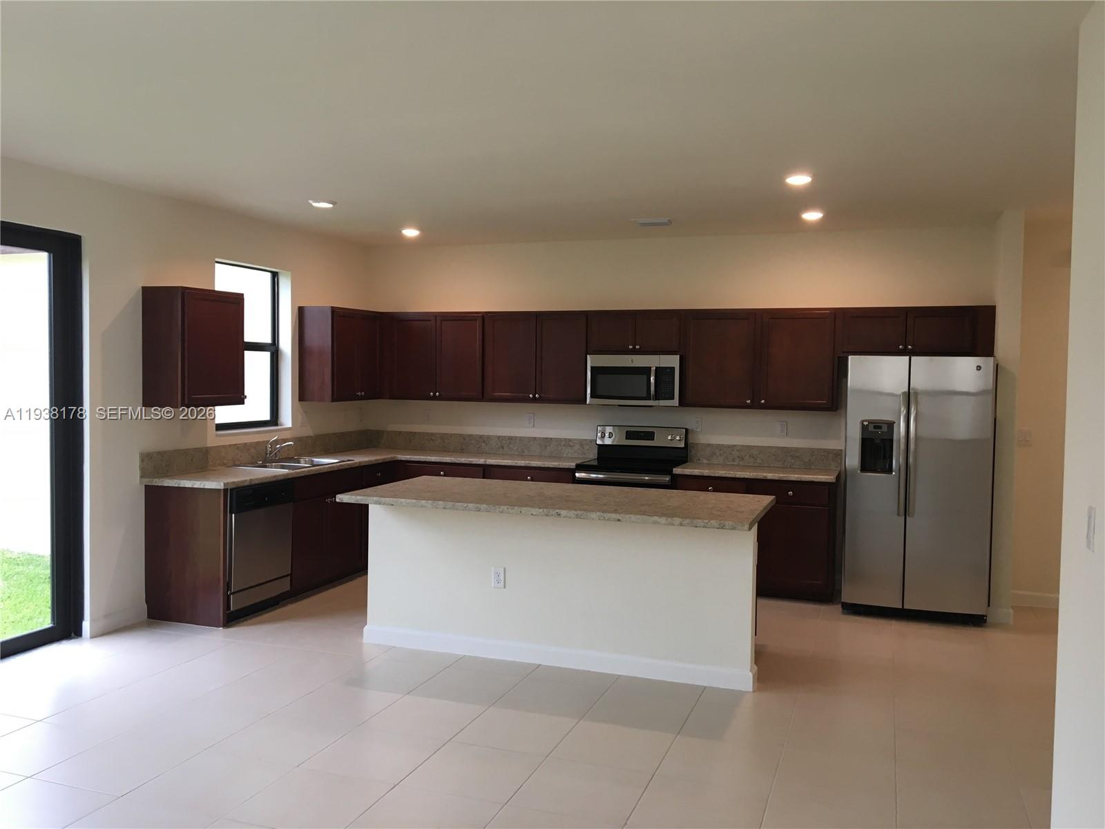 A kitchen features dark wood cabinets, stainless steel appliances, and a central island with countertops — 191 SE 35 TH AV., Homestead FL 33033, HOMESTEAD, FL