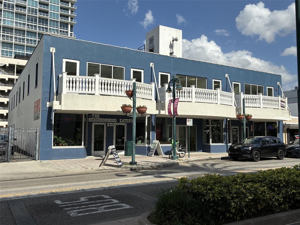 A two-story blue commercial building with a white balcony and ground-level storefronts — 227 N MAGNOLIA AVENUE UNIT 206, ORLANDO, FL