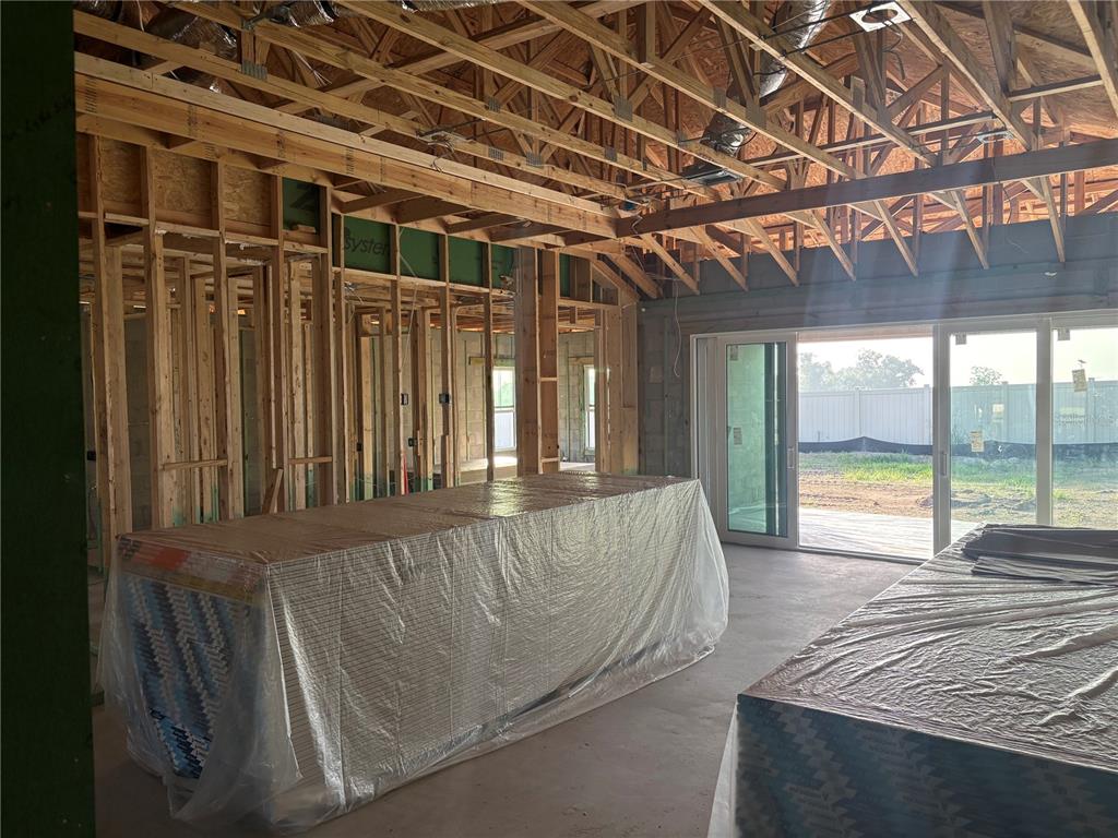 An open-concept living area features wood-look flooring, recessed lighting, and large sliding glass doors — 9806 LEAF GREEN LANE, DADE CITY, FL