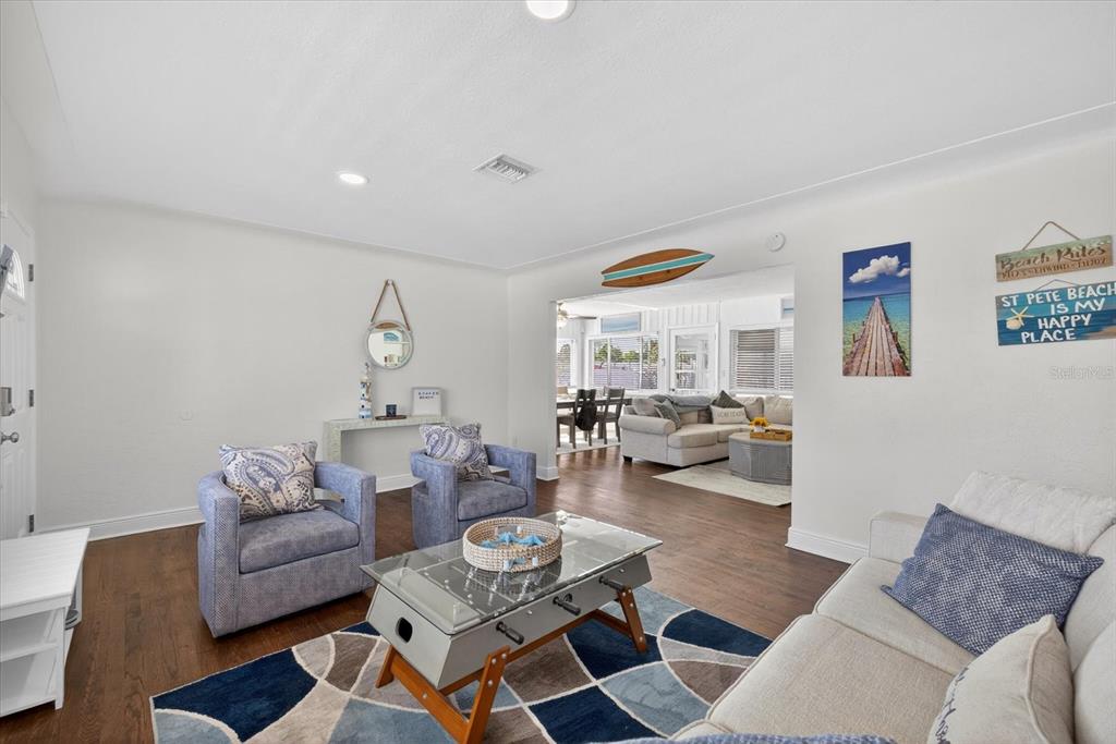 A living room features hardwood floors, a foosball coffee table, and an open floor plan — 292 42ND AVENUE, ST PETE BEACH, FL