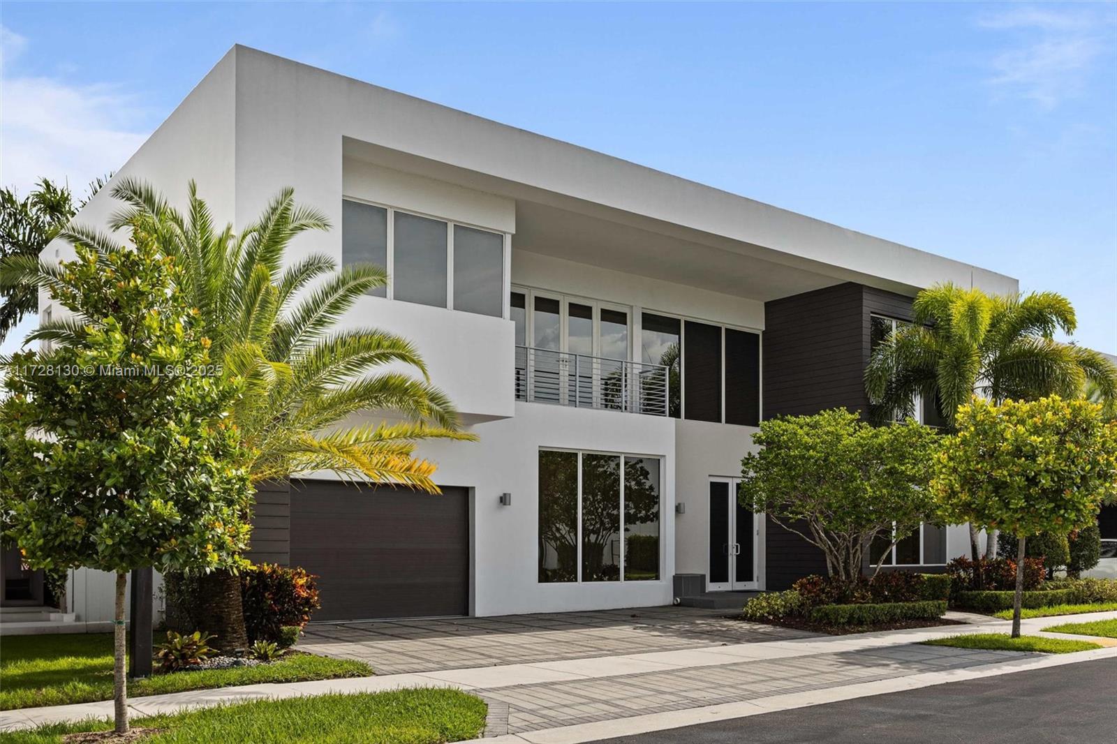 A modern two-story house features a white facade, dark wood accents, and a paved driveway — 10296 NW 74th Ter, Doral FL 33178, DORAL, FL