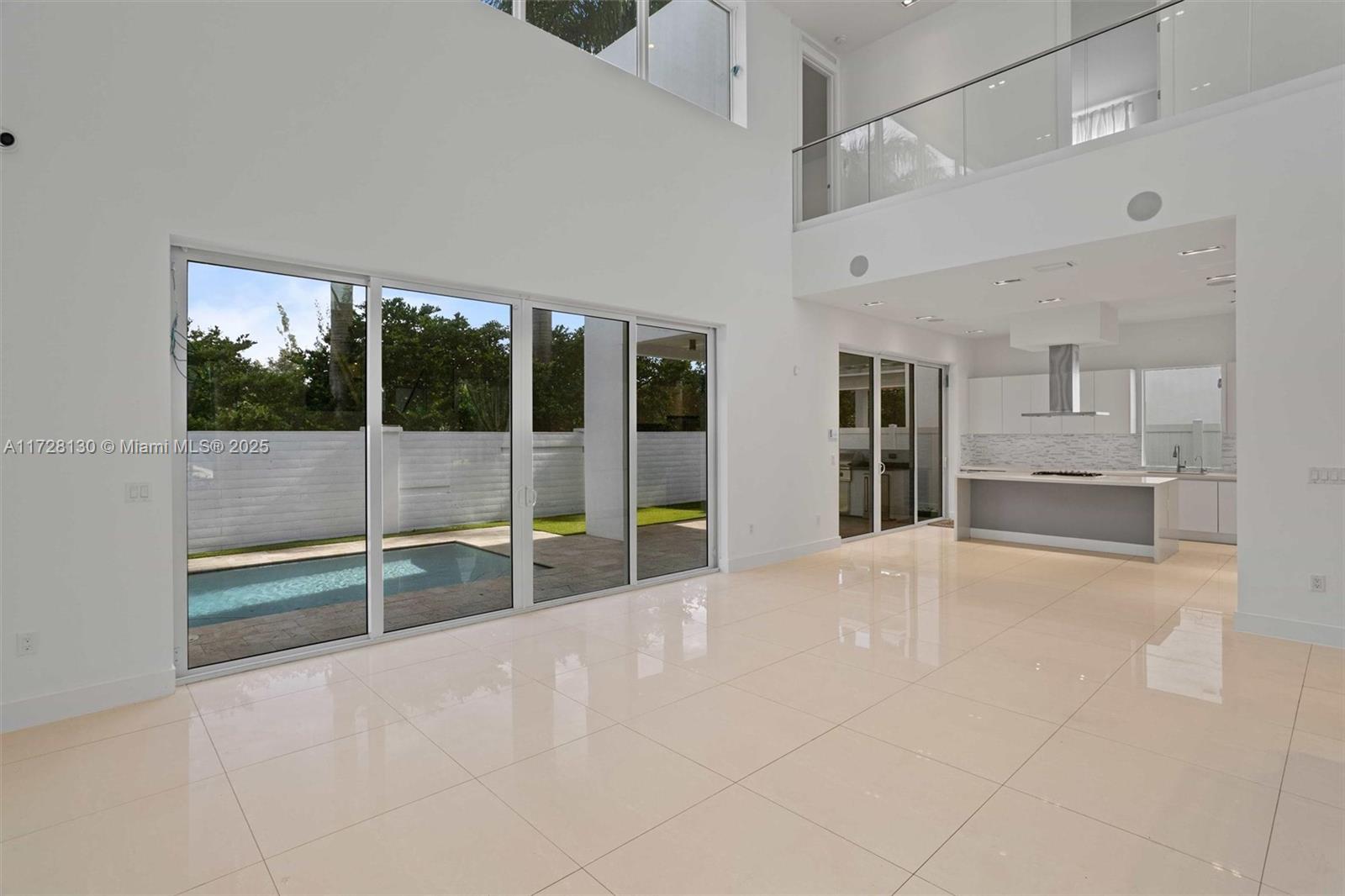 A bright, open-concept living area features white tile floors, high ceilings, and a modern kitchen — 10296 NW 74th Ter, Doral FL 33178, DORAL, FL