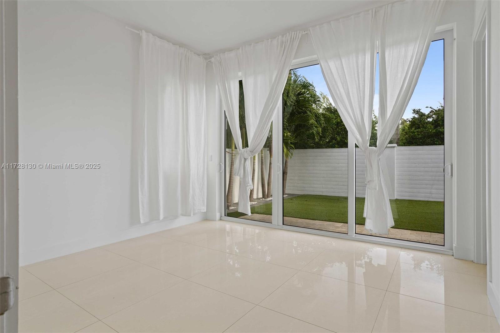 A bright room features white walls, large tile flooring, and sliding glass doors with curtains — 10296 NW 74th Ter, Doral FL 33178, DORAL, FL