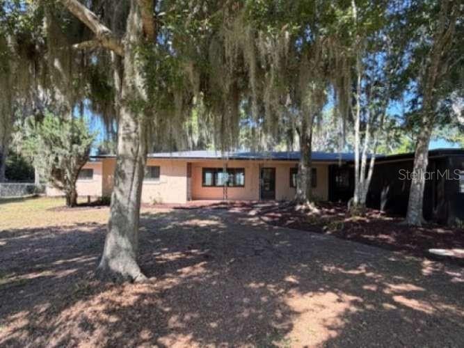 A wood-paneled room features a built-in bar with stools and a ceiling fan — 930 SHORE DRIVE, KISSIMMEE, FL