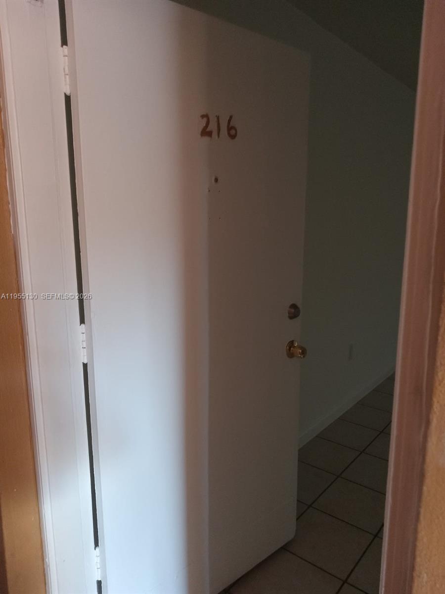 A white door labeled 216 opens into a room with tiled flooring — 1230 W 54th St # 216A, Hialeah FL 33012, HIALEAH, FL
