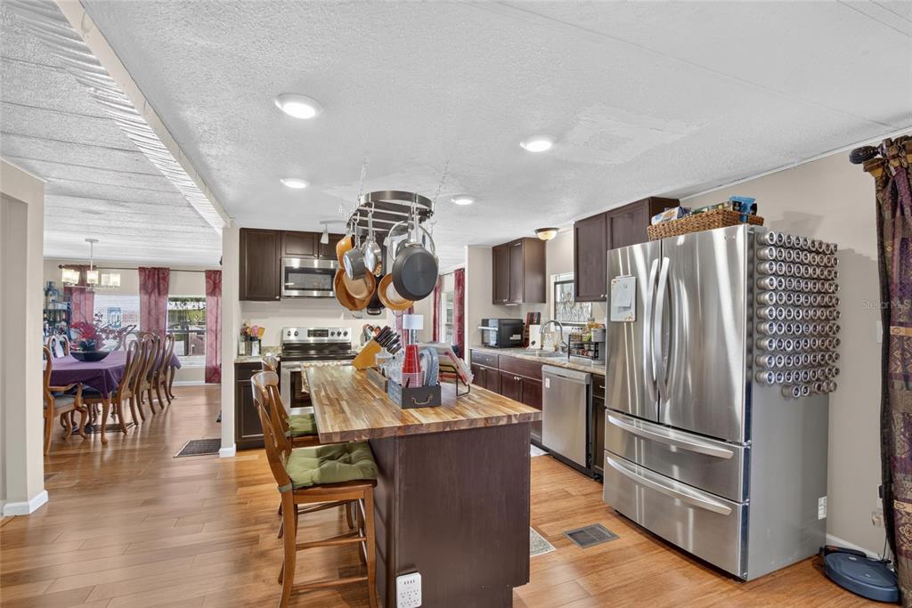 A kitchen with dark wood cabinets, a wooden island, and stainless steel appliances — 2715 EATON AVENUE, EATON PARK, FL