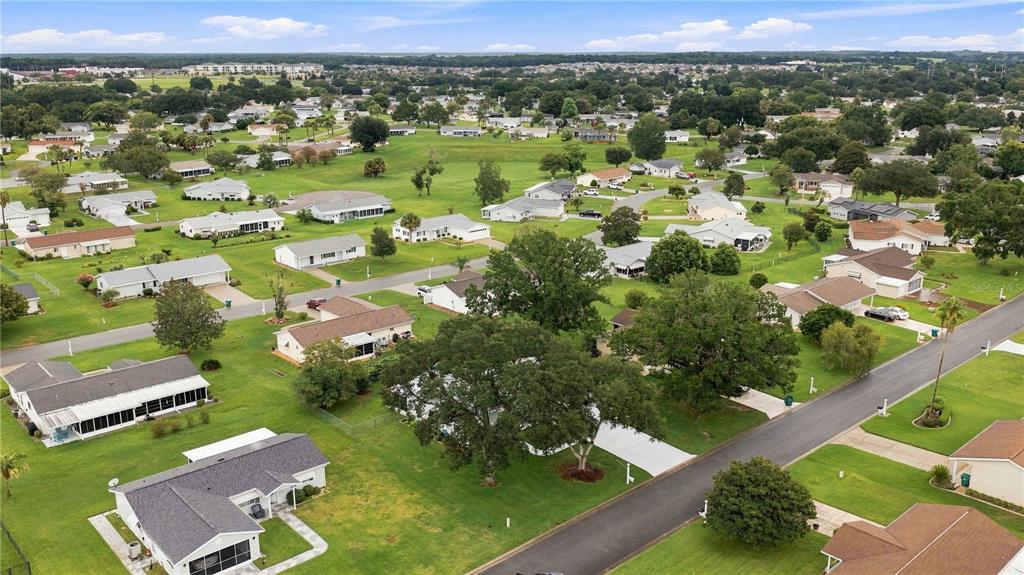 An aerial view of a residential neighborhood with single-family homes, green lawns, and mature trees — 10435 SE 178TH PLACE, SUMMERFIELD, FL