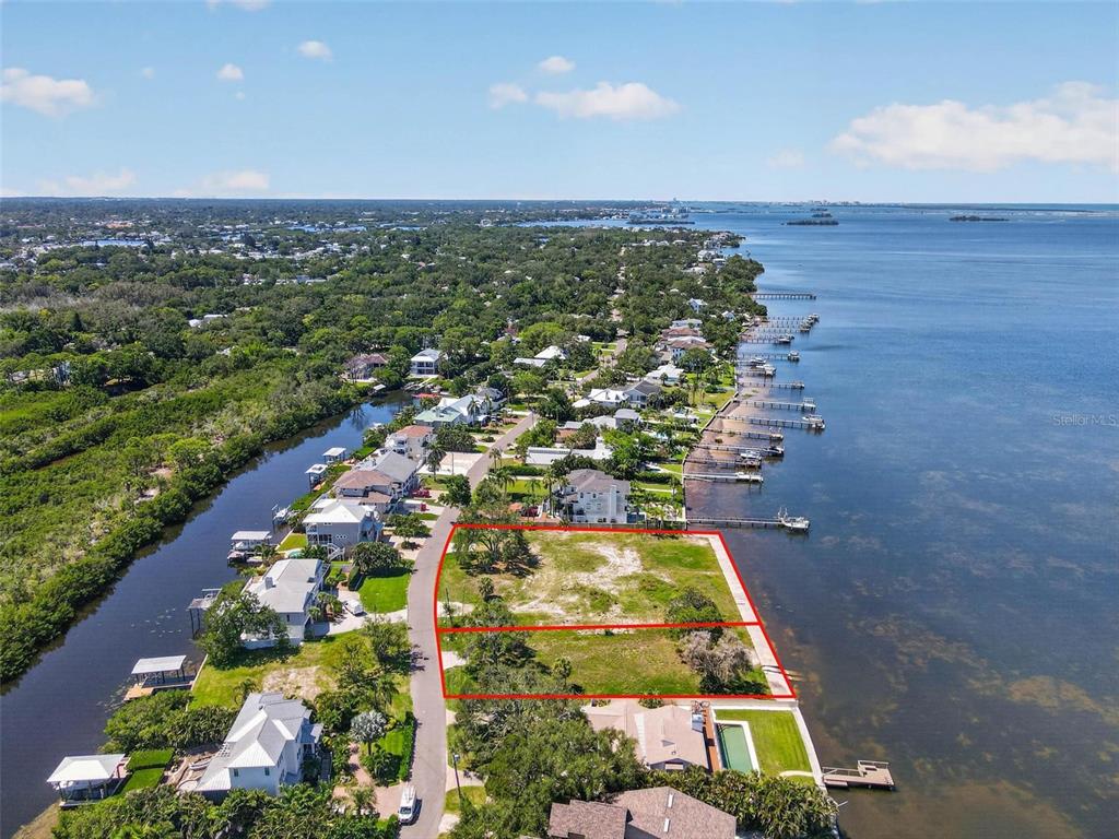 An aerial view shows two adjacent vacant waterfront lots along a residential street — MAYO STREET, PALM HARBOR, FL