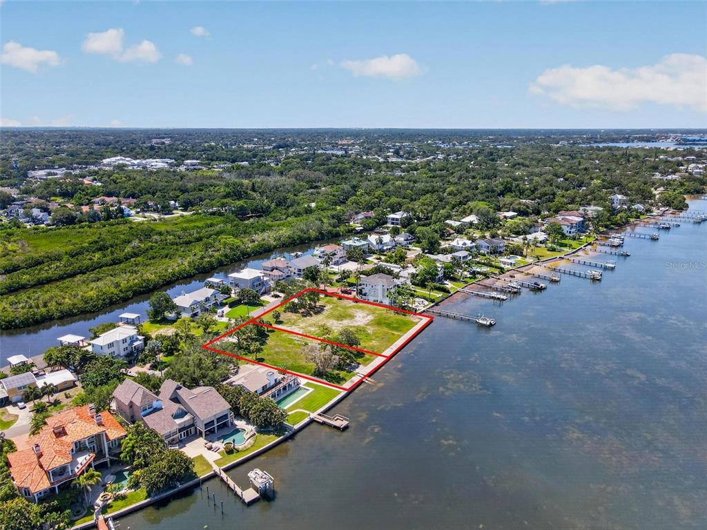 An aerial view shows two adjacent waterfront vacant lots outlined in red along a bay — MAYO STREET, PALM HARBOR, FL
