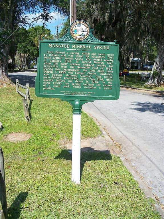 A green historical marker sign stands on a post in a grassy area near a road — CHANNING AVENUE, NORTH PORT, FL