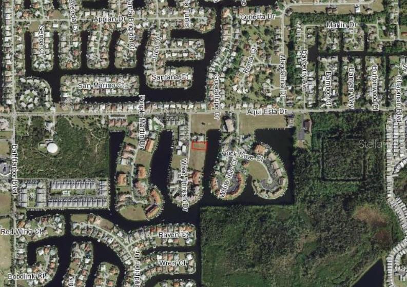 This is an aerial map showing a vacant residential lot highlighted in red near water — 3234 WOOD THRUSH DRIVE, PUNTA GORDA, FL