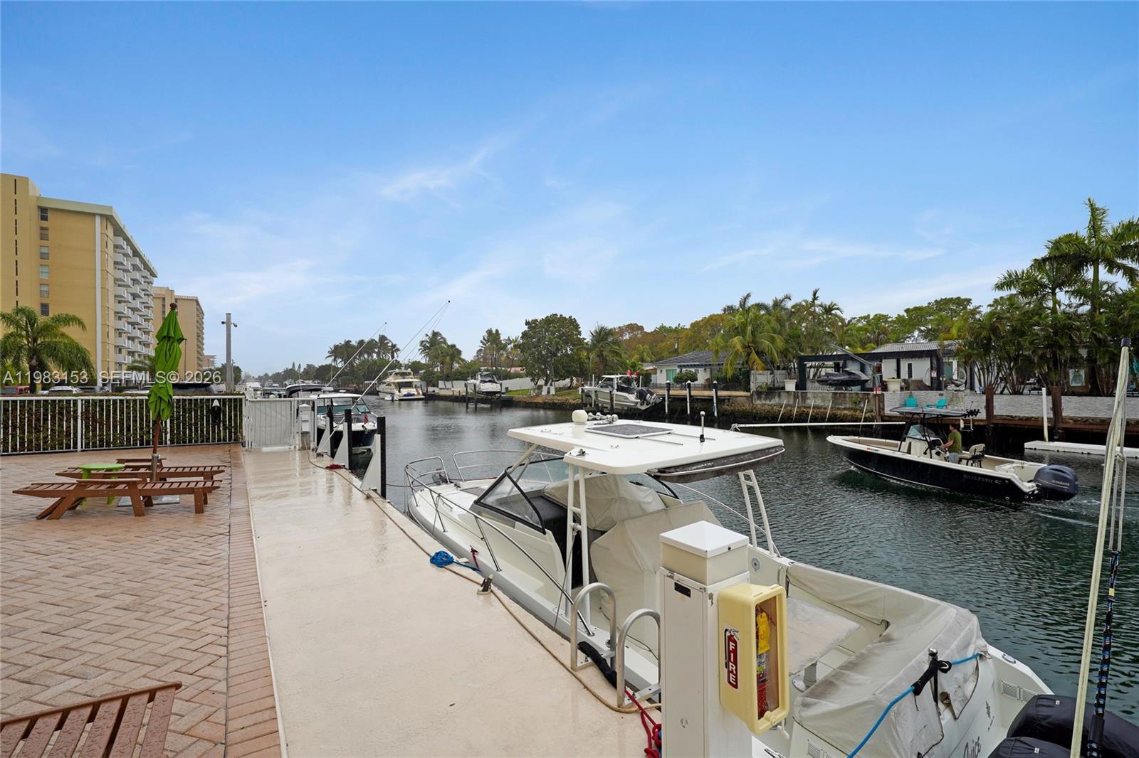 A boat is docked at a concrete pier along a canal lined with houses — 2000 NE 135th St # 1010, North Miami FL 33181, NORTH MIAMI, FL