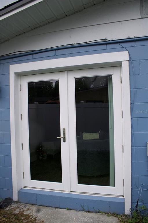 A set of white French doors is installed in a blue concrete block exterior wall — 315 AMADOR CIRCLE, ORLANDO, FL