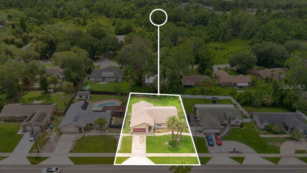 An aerial view shows a single-story house with a tan roof and a front driveway — 1141 DOYLE ROAD, DELTONA, FL