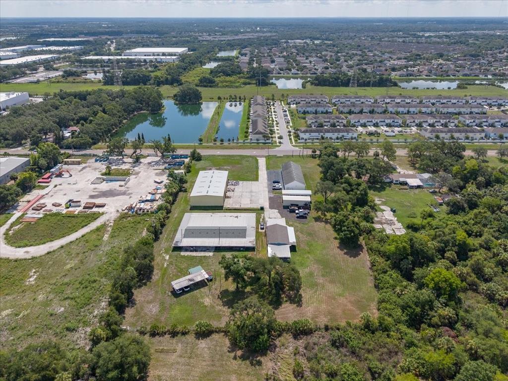 An aerial view shows a commercial property with several warehouse buildings and surrounding green space — 6901 S 78TH STREET, RIVERVIEW, FL