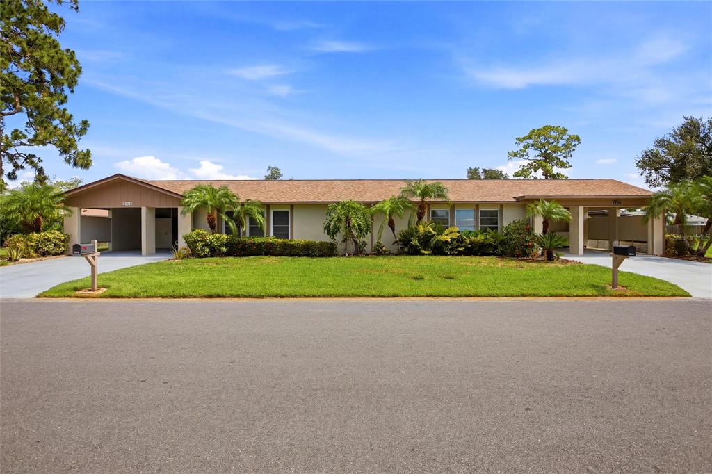 A single-story house with a tan exterior, a brown shingled roof, and two attached carports — 3721 COLLINS STREET UNIT 812, SARASOTA, FL