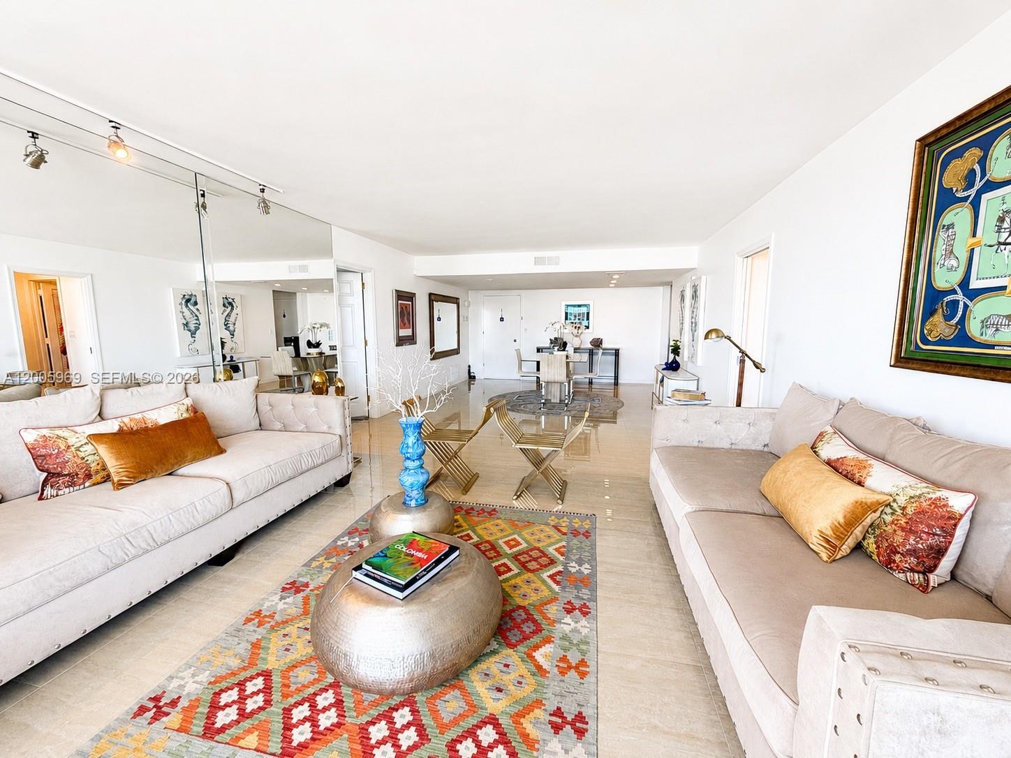 A living room features two beige sofas, a colorful patterned rug, and mirrored walls — 2773 S Ocean Blvd # 4070, Palm Beach FL 33480, PALM BEACH, FL