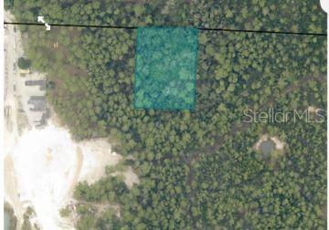 An aerial view shows a rectangular plot of land highlighted in teal within a wooded area — 7157 WINDWOOD LANE, MILTON, FL
