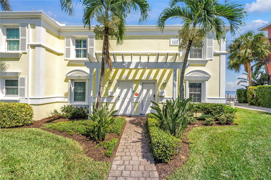 A two-story yellow building with a stone walkway leading to two front doors — 4982 COQUINA KEY DRIVE SE, ST PETERSBURG, FL