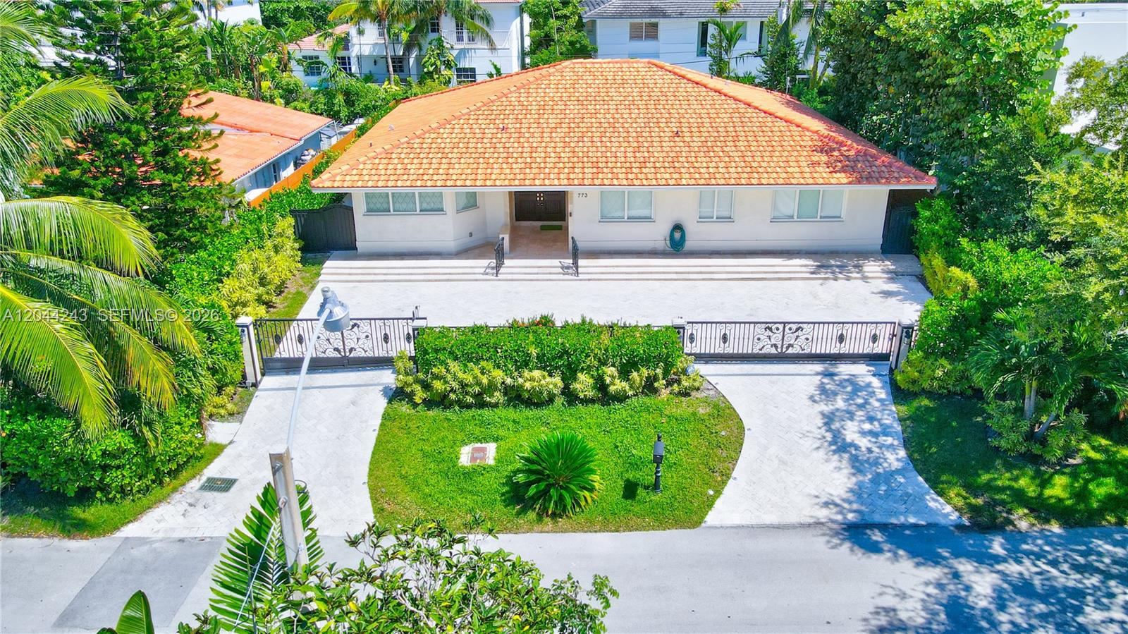 An aerial view shows a single-story house with a terracotta tile roof and gated driveway — 773 Woodcrest Rd, Key Biscayne FL 33149, KEY BISCAYNE, FL