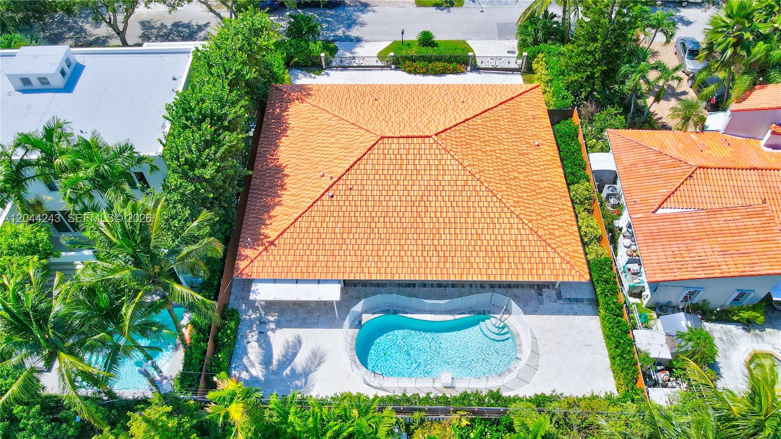 An aerial view shows a house with an orange tile roof and a backyard pool — 773 Woodcrest Rd, Key Biscayne FL 33149, KEY BISCAYNE, FL