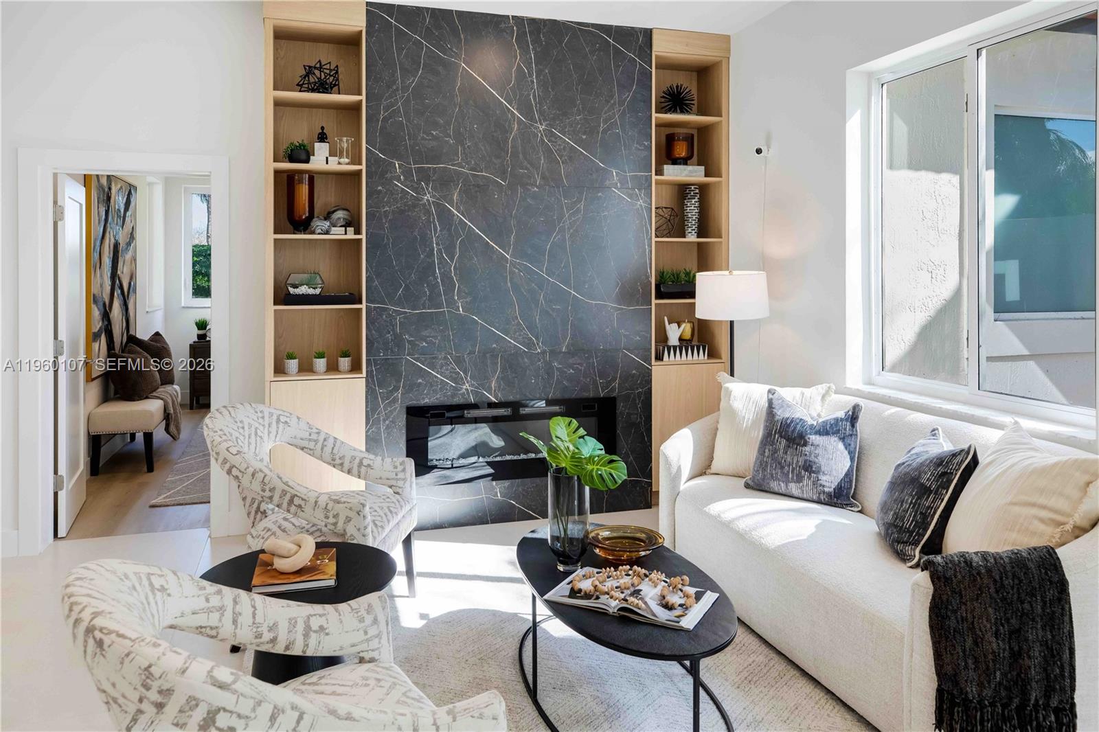 A living room features a black marble fireplace wall flanked by light wood built-in shelves — 16012 Opal Creek Dr, Weston FL 33331, WESTON, FL