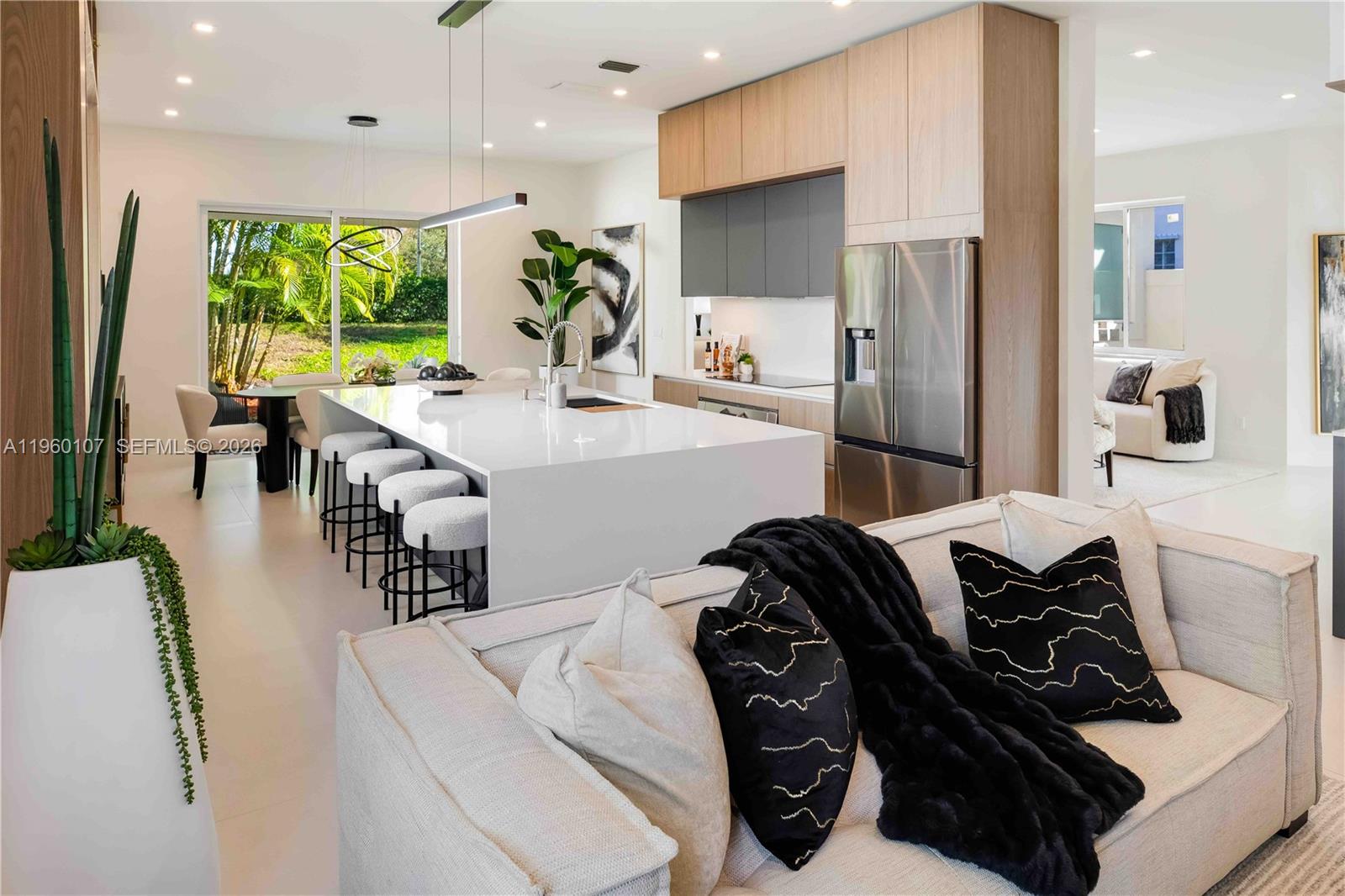 A modern kitchen features a large white island, stainless steel appliances, and light wood cabinetry — 16012 Opal Creek Dr, Weston FL 33331, WESTON, FL