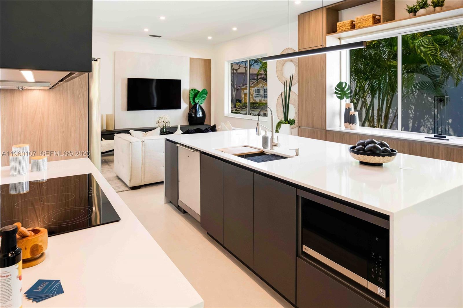 A modern kitchen features a large white island with dark cabinetry and a stainless-steel dishwasher — 16012 Opal Creek Dr, Weston FL 33331, WESTON, FL