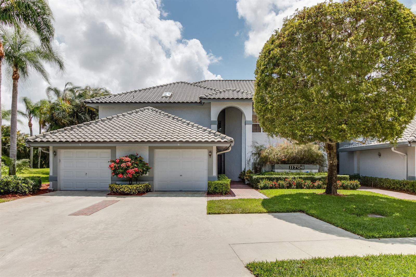 A two-story house with a two-car garage, tile roof, and a large tree in front — 11706 Briarwood Circle # 1, Boynton Beach FL 33437, BOYNTON BEACH, FL