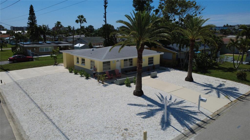 An aerial view shows a yellow single-story house with a white gravel yard and palm trees — 1404 COREY WAY S, SOUTH PASADENA, FL
