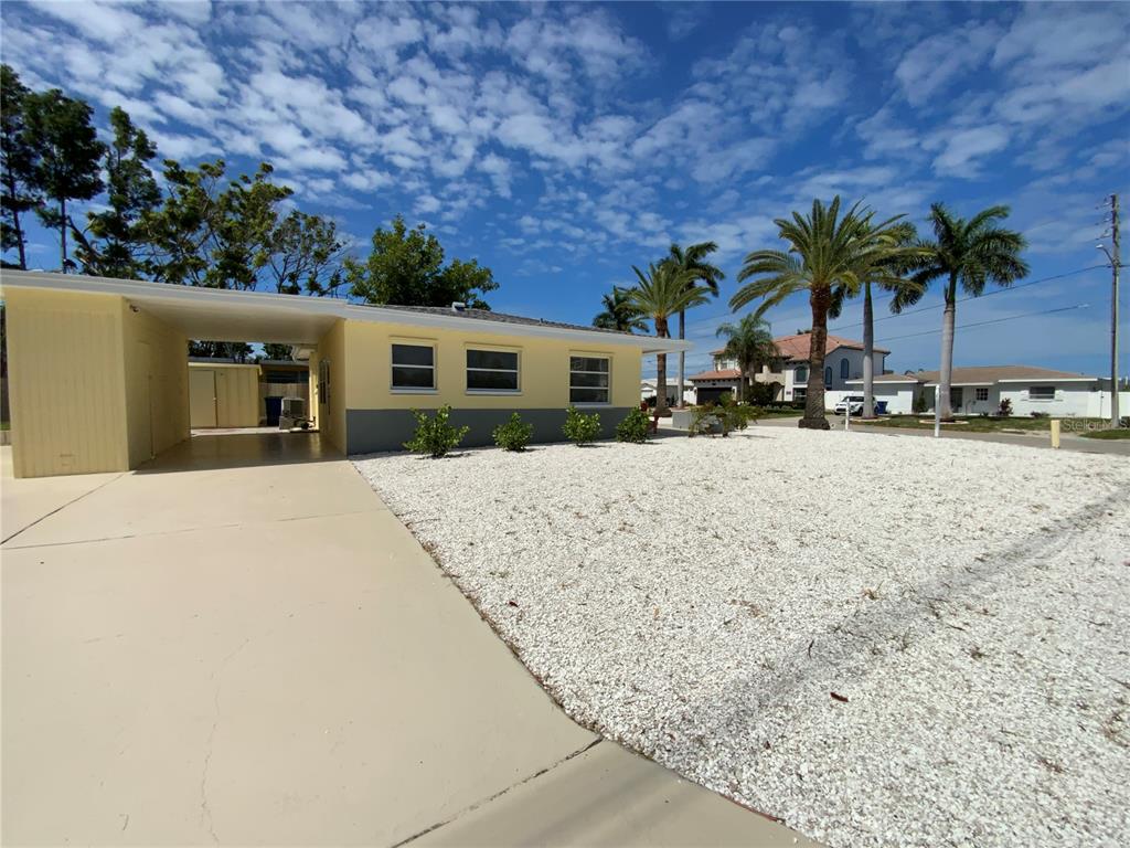 A single-story house with a yellow and gray exterior and a concrete carport — 1404 COREY WAY S, SOUTH PASADENA, FL