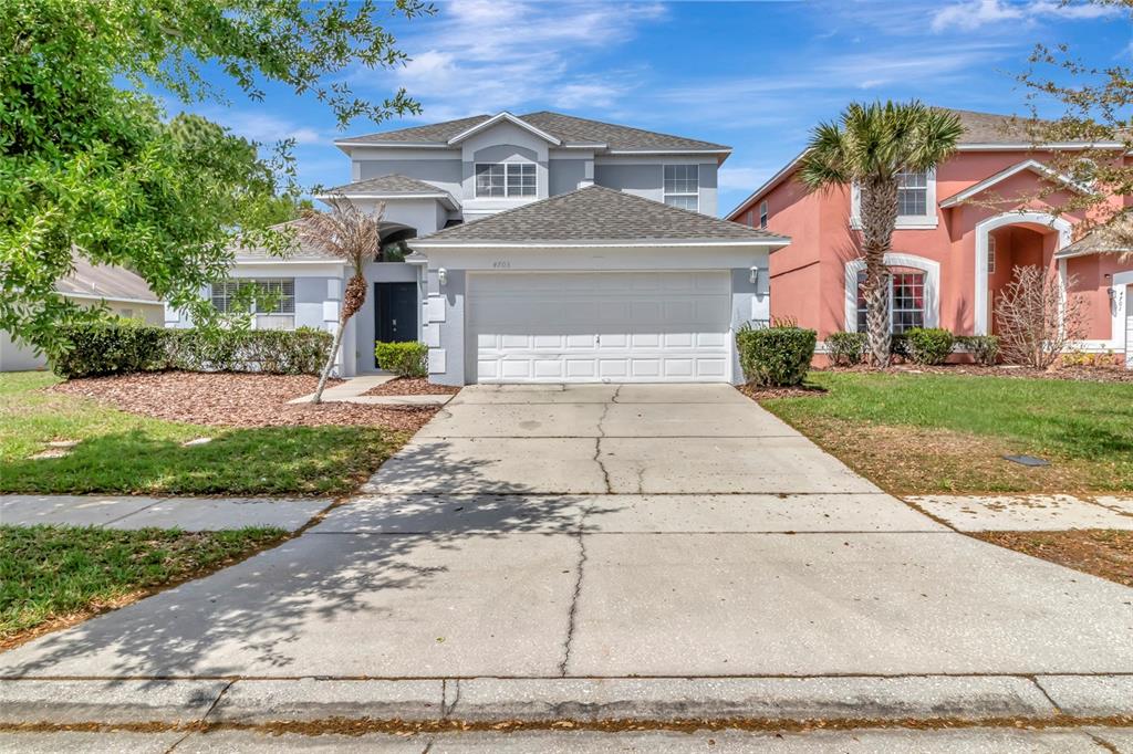 A two-story gray house with a two-car garage and a concrete driveway — 4703 GOLDEN BEACH COURT, KISSIMMEE, FL