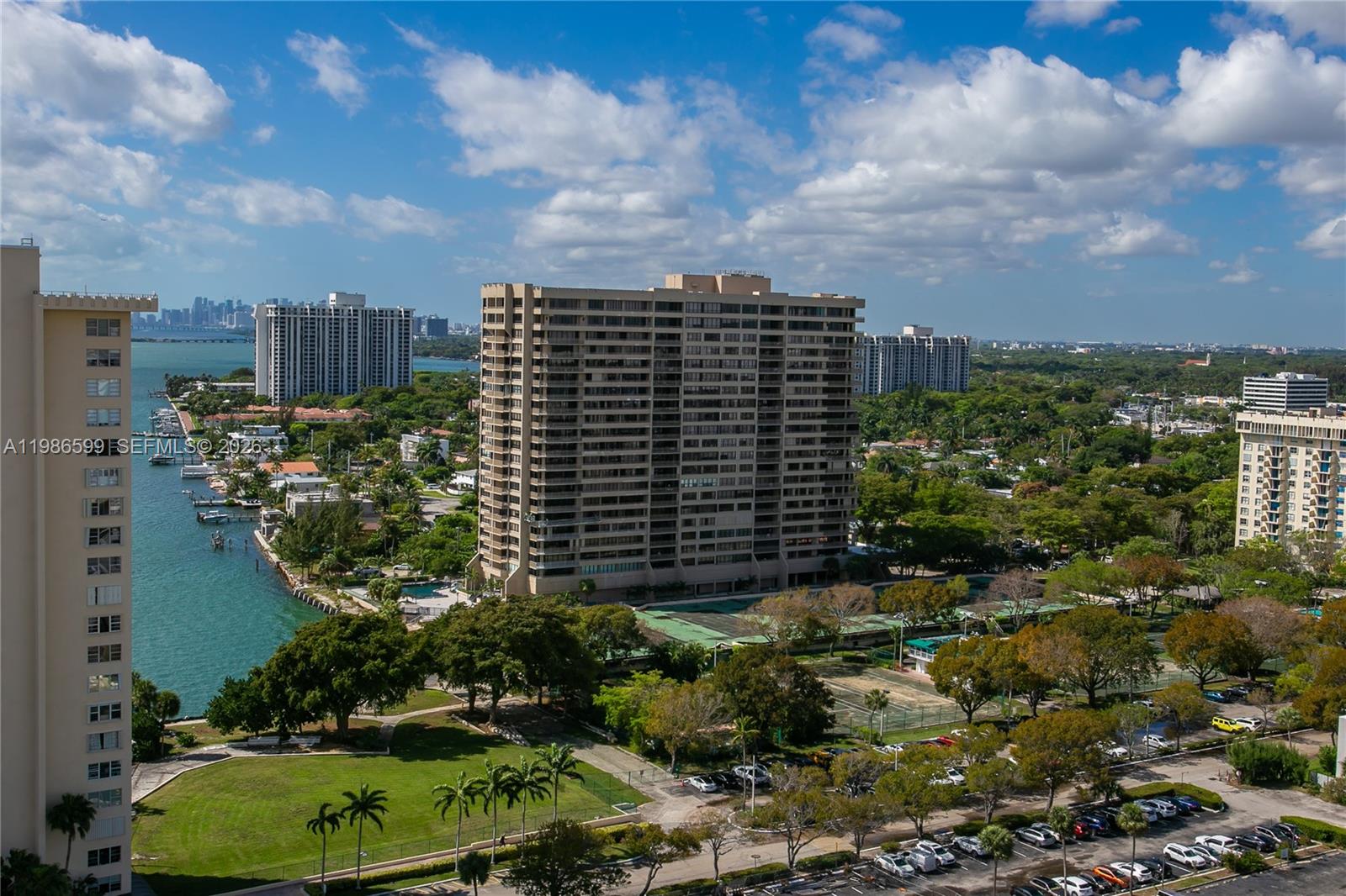 An elevated view shows a tall apartment building overlooking a waterway, park, and parking lot — 1800 NE 114th St # 2309, Miami FL 33181, MIAMI, FL